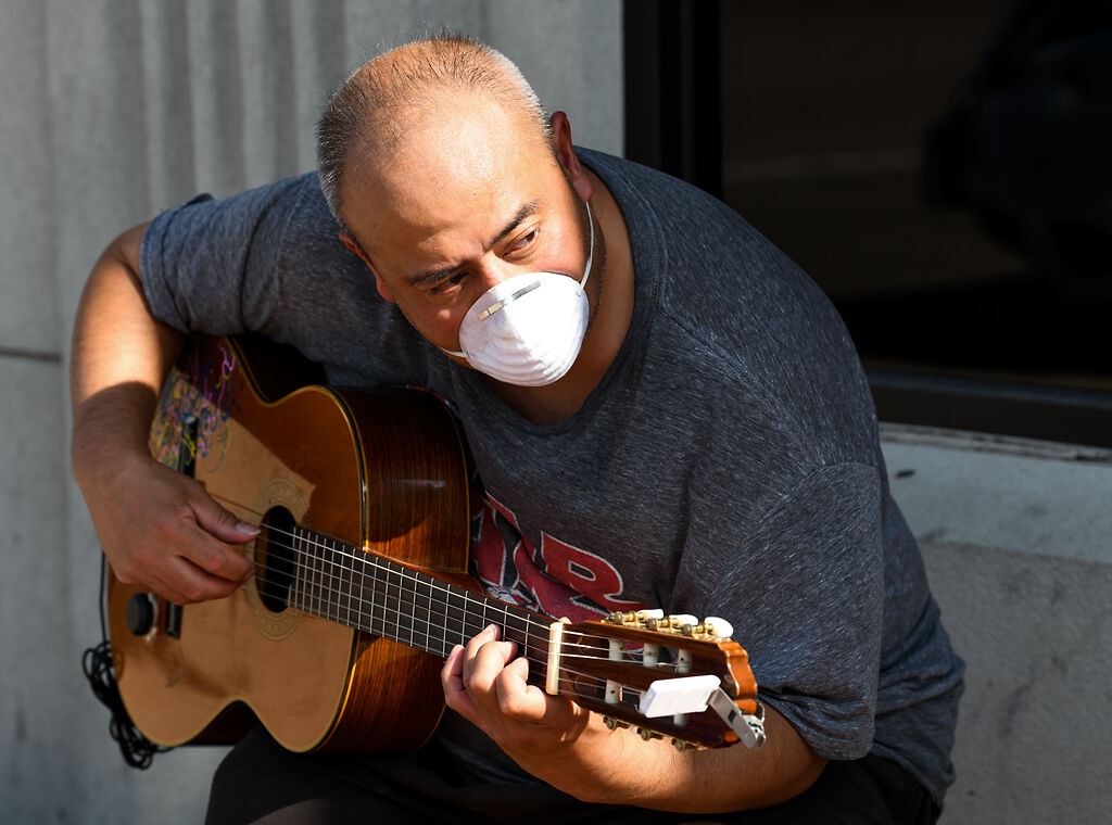 Mike del Rosario plays acoustic guitar